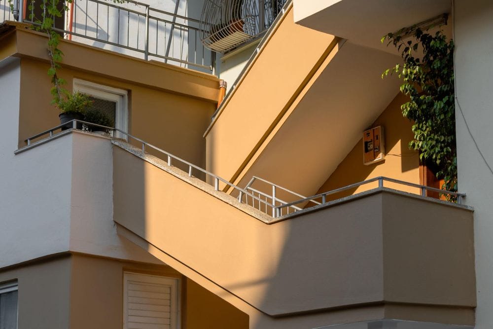 Exterior stairs on a multi-story apartment building showing elevated structural components and railing system